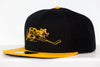 Cape Cod Cubs Hat (Snapback) in black and yellow with vintage cartoon bear playing hockey embroidered on front panel