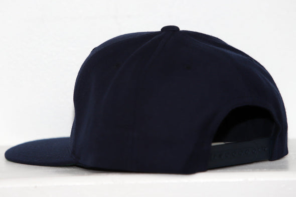 Back view of a navy blue Wichita Wind snapback hat with adjustable strap on a white background